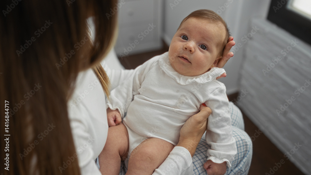 Woman holding baby in cozy home environment, showcasing family bond and love indoors.