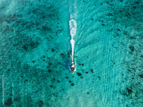 Obraz na płótnie Boat cruising through turquoise waters with white wake trailing behind, captured from directly above in Thailand. w salonie