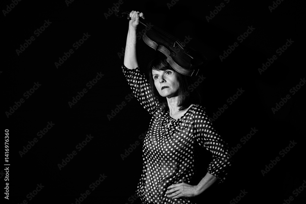 Obraz premium Woman raising violin above head in black and white