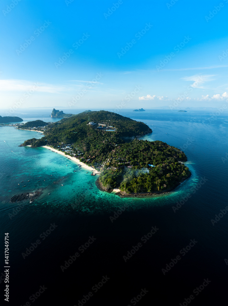 Top-down aerial shot of Phi Phi Don island, showcasing tropical beaches, lush vegetation, and clear turquoise waters in southern Thailand.