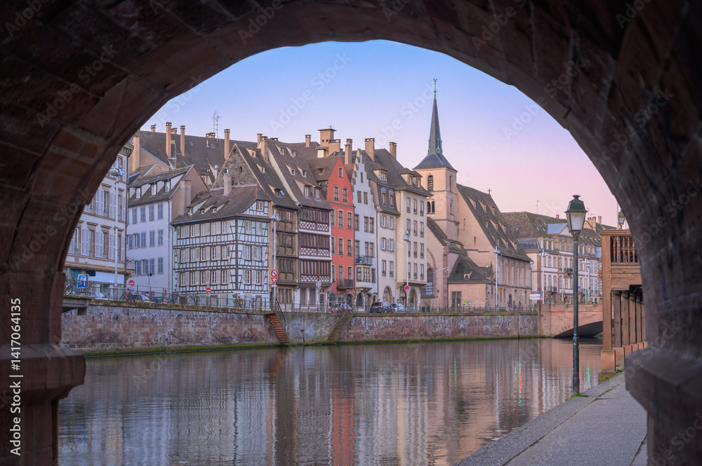 Beautiful sunset view of Strasbourg canals with historic buildings reflecting on the water