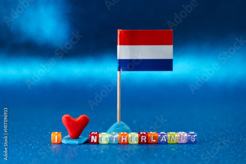 Obraz na płótnie Colorful decorations displaying love for Netherlands with a small flag and heart on a vibrant blue surface during an artistic arrangement w salonie