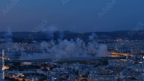 2026 firework shape , Cityscape Night Urban Skyline with Smoke Rising over Illuminated Buildings during Dusk | Blue Hour