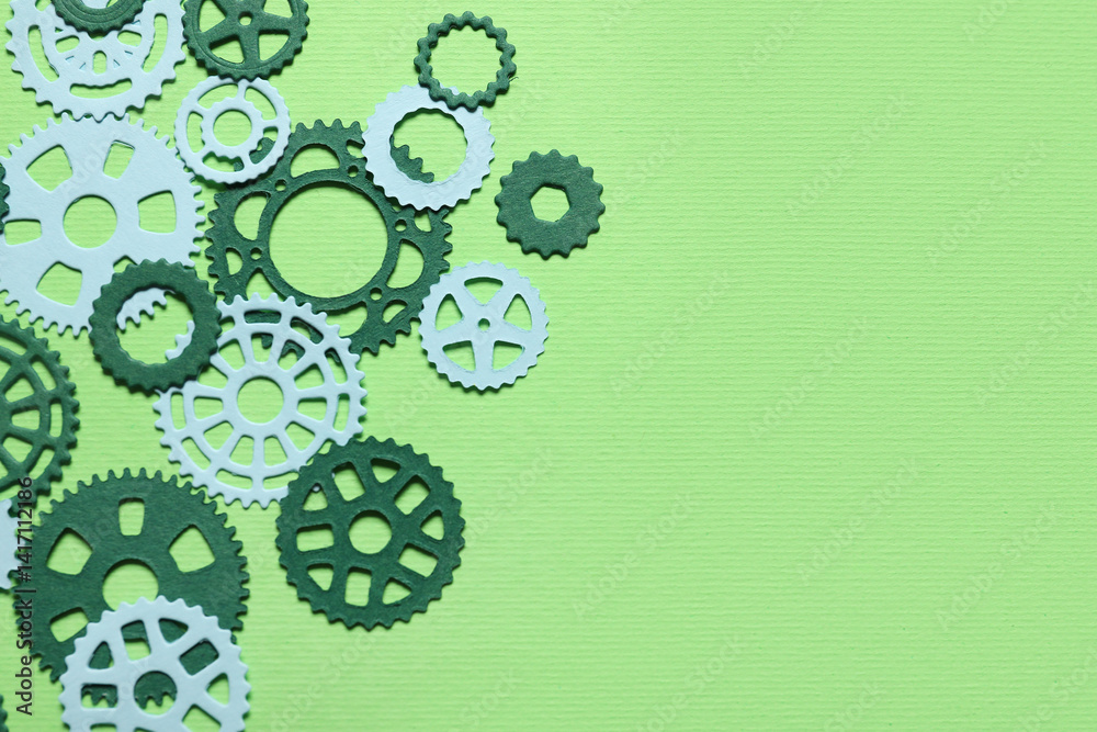 Fototapeta premium Different paper gears on green background