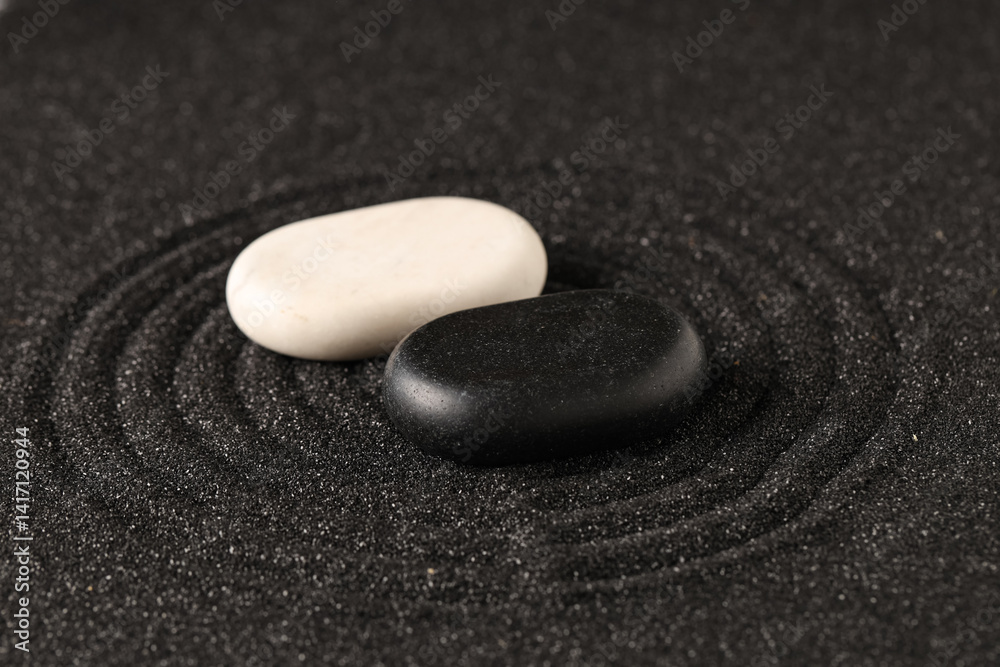 Stones on black sand with lines. Yin Yang concept