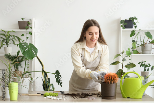 Smiling woman repotting cac...