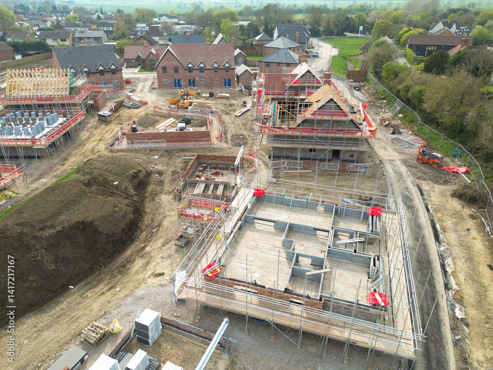 Low level aerial view of partially completed new homes on a housing development site in rural Britain. Both private and affordable homes will be for sale in this village.