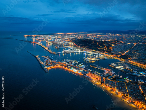 Aerial photo of Port of Barcelona at night with city lights and cruise ships