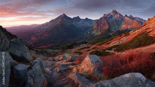 Panoramic view of  Mountains at sunrise with red-orange rock peaks and golden light.