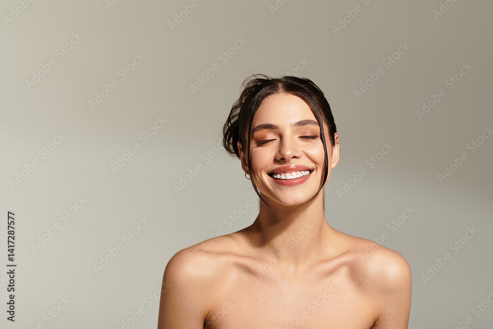 Obraz premium Joyful expression of a young beautiful woman radiating happiness in a minimalist setting