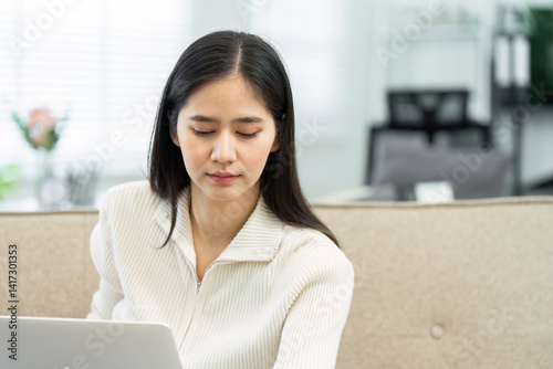 Working from Home and Productivity. A focused woman engaged in digital work at her stylish home office. Free Download Working from Home and Productivity. A focused woman engaged in digital work at her stylish home office. - GFXLoad
