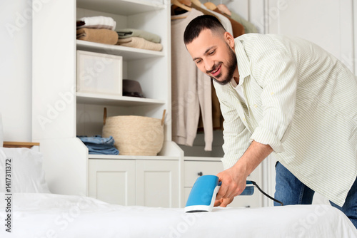 Young man steaming blanket ...