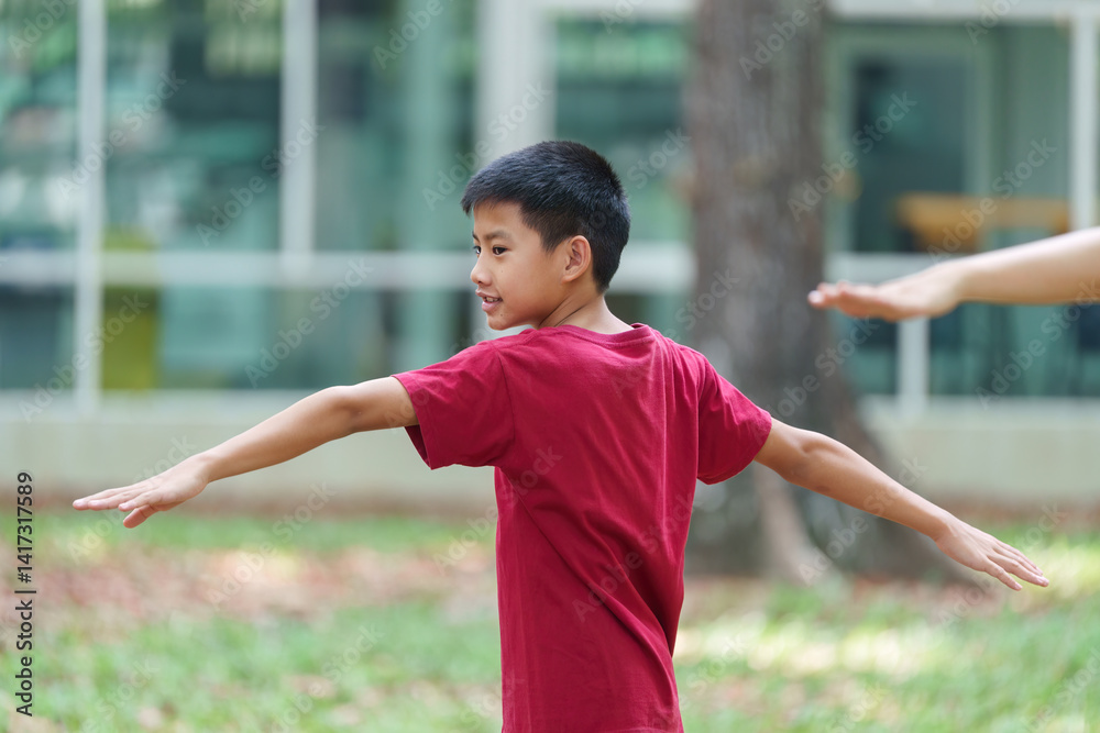 Active Play and Movement. A boy practices balance and stretches during fun outdoor exercises with his mom. Active Play and Movement. A boy practices balance and stretches during fun outdoor exercises with his mom.
