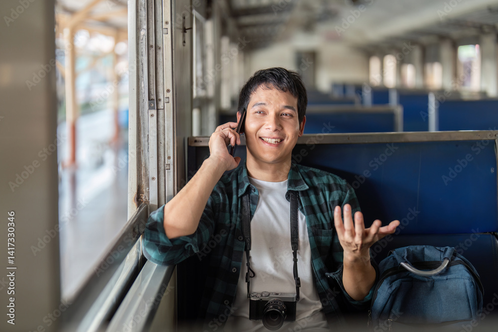 Fototapeta premium Travel and Connectivity. A young man happily chatting on the phone while embarking on a journey.