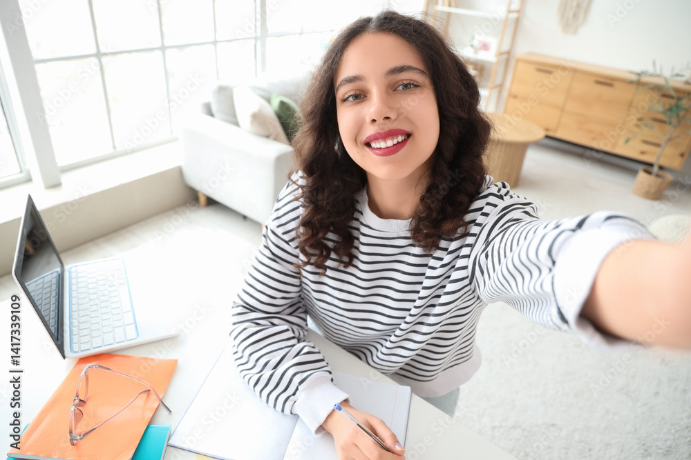 Female Indian student taking selfie while studying at home Female Indian student taking selfie while studying at home