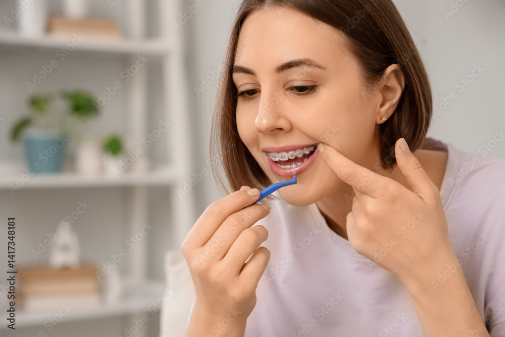 Young woman with dental braces cleaning teeth at home, closeup Young woman with dental braces cleaning teeth at home, closeup
