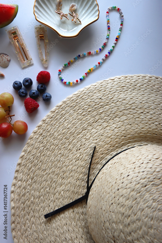 Straw hat, sunglasses, seasonal fruit, seashells and colorful accessories on white backgrounds. Cute summer essentials. Flat lay.