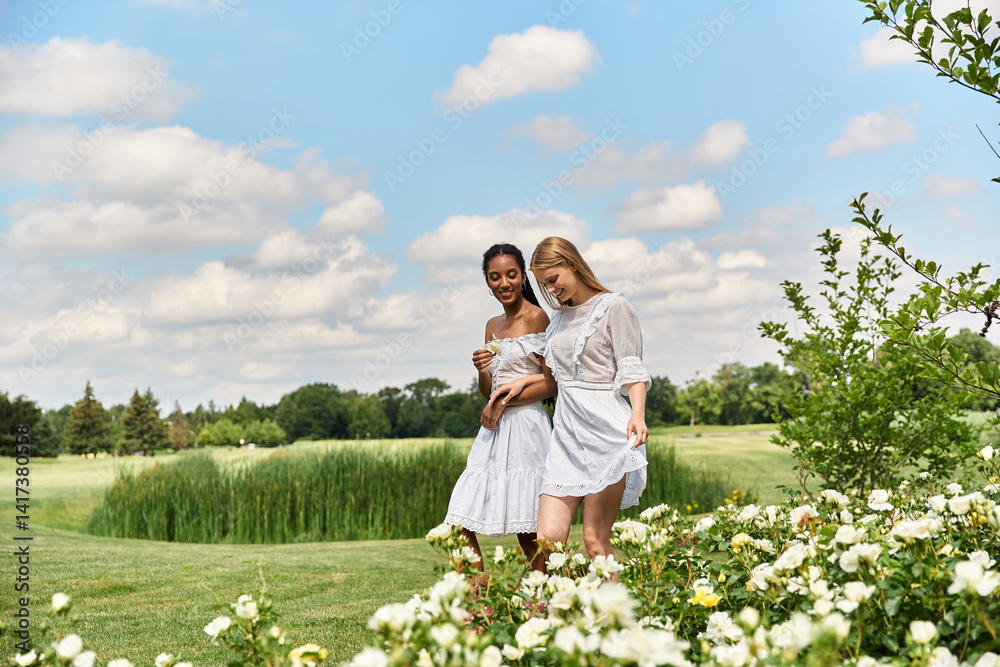 Young beautiful lesbian couple enjoying a sunny day together in a blooming garden landscape Young beautiful lesbian couple enjoying a sunny day together in a blooming garden landscape