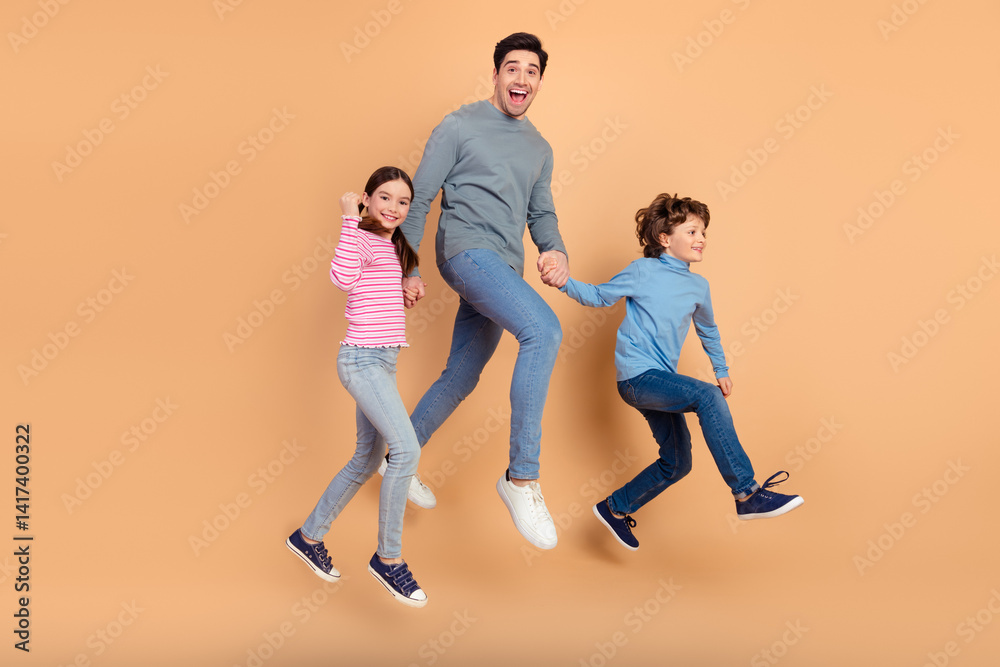 Obraz premium Cheerful Family Jumping Together Against Beige Background Celebrating Happiness and Bonding
