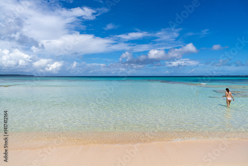 Obraz na płótnie Woman with snorkel enters crystal-clear water for snorkeling in Okinawa, Japan w salonie