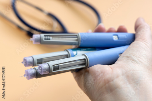 Women's hands holding lots of Insulin injection pen for diabetics and weight loss.