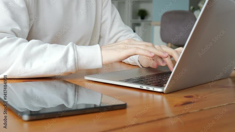 A person concentrates on their tasks, typing on a laptop in a welcoming and warm atmosphere. A person concentrates on their tasks, typing on a laptop in a welcoming and warm atmosphere.