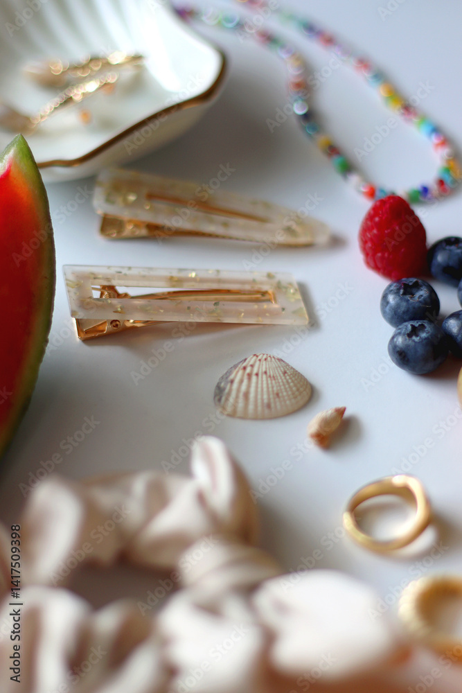 Straw hat, sunglasses, seasonal fruit, seashells and colorful accessories on white backgrounds. Cute summer essentials. Selective focus.