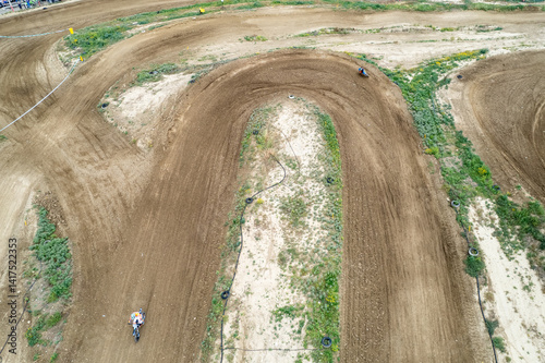 Obraz na płótnie Motocross racers riding on dirt track. Drone aerial view of the motocross circuit w salonie