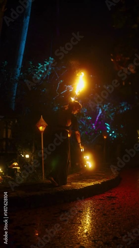 Show of dancing with fires, performance using burning torches in night. Fire dancer performs. Vertical shot