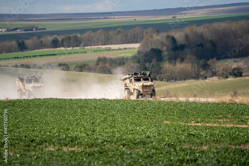 Obraz na płótnie a British army Foxhound rapid support vehicle movong along a dirt track at speed w salonie