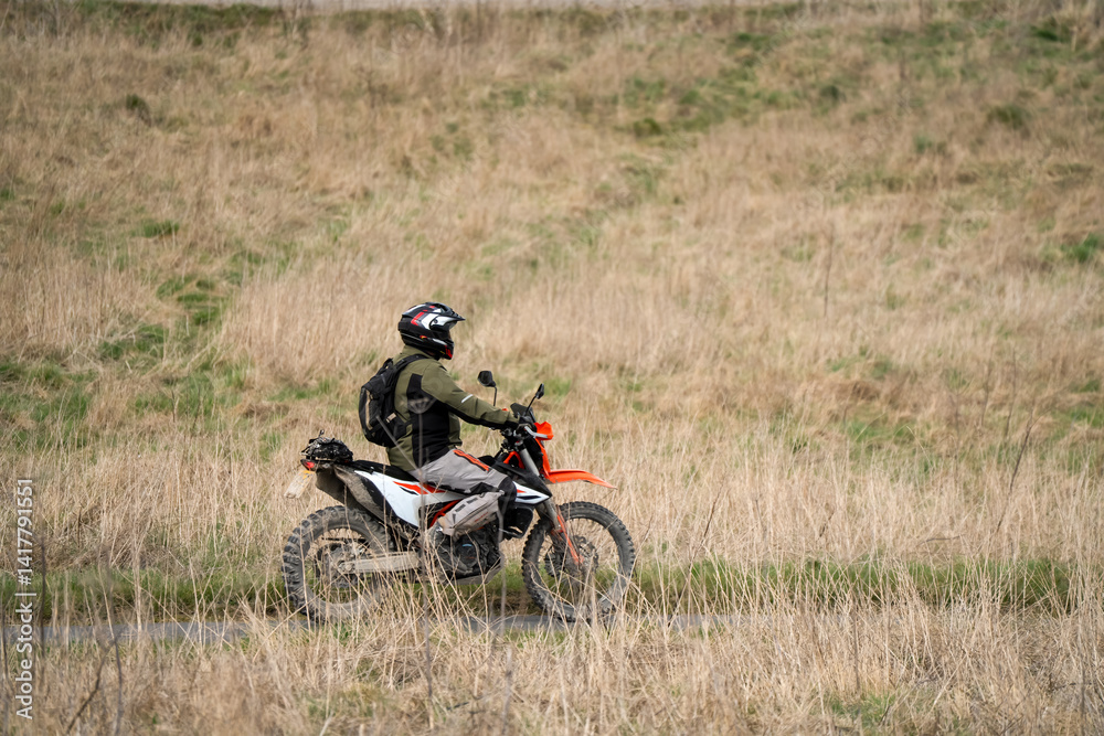 motor cyclist (biker) riding their off-road motorbike through countryside