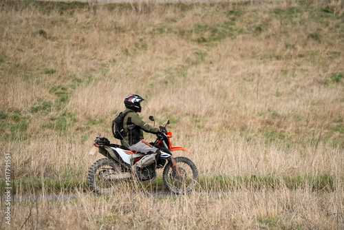 Obraz na płótnie motor cyclist (biker) riding their off-road motorbike through countryside w salonie
