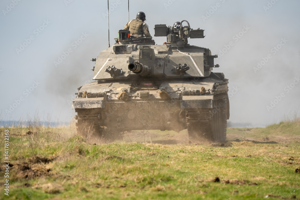 close-up of a commander directing a Challenger 2 II FV4034 main battle tank, reversing away at high speed