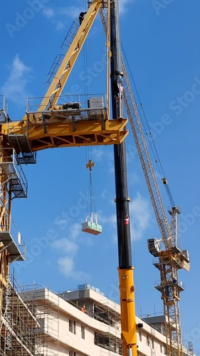 Tower crane or mobile crane erected beside under construction building.
Yellow color Tower crane lifting heavy items from ground to top level
Building Portable Tower Cranes for under construction site