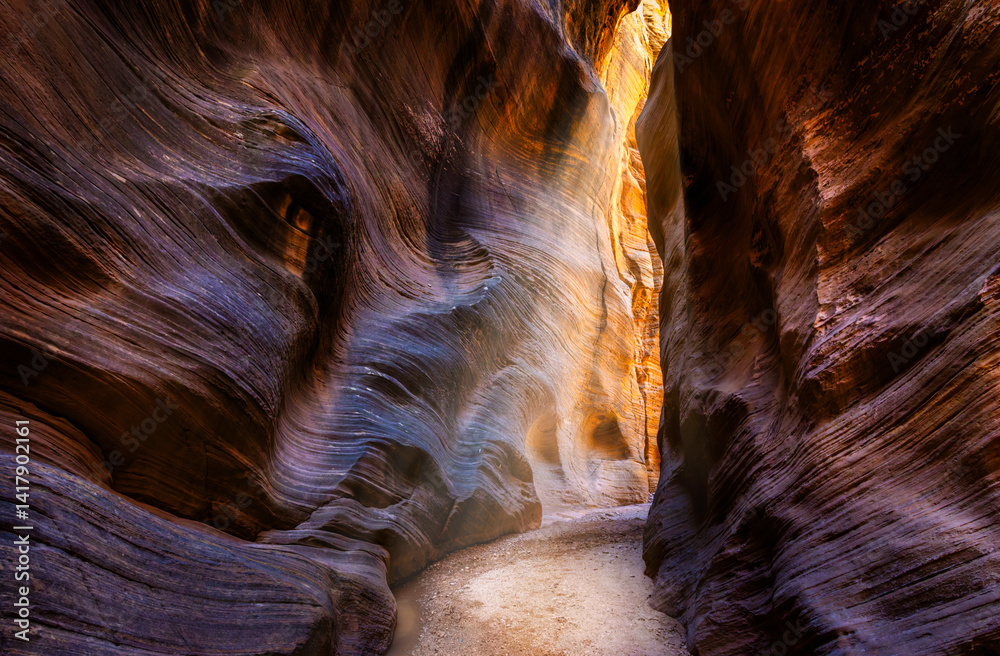 Sunbeams through Willis Creek Slot Canyon in Utah. Willis Creek is a creek in Bryce Canyon National Park, and the Grand Staircase Escalante National Monument in Garfield and Kane counties