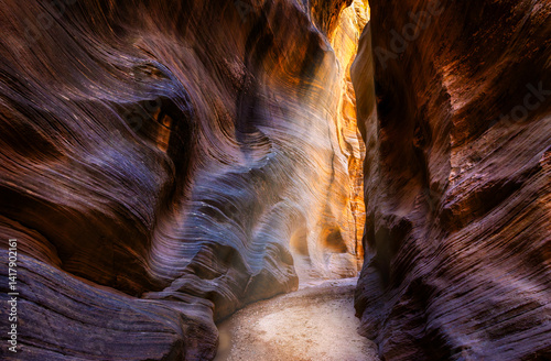 Obraz na płótnie Sunbeams through Willis Creek Slot Canyon in Utah. Willis Creek is a creek in Bryce Canyon National Park, and the Grand Staircase Escalante National Monument in Garfield and Kane counties w salonie