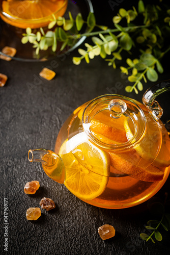 Obraz na płótnie Glass teapot with hot citrus tea from oranges, lemons and limes, healthy drink on dark background w salonie