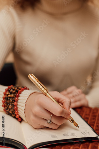 A woman makes entries in a diary. A woman's hand with a pen. Planning