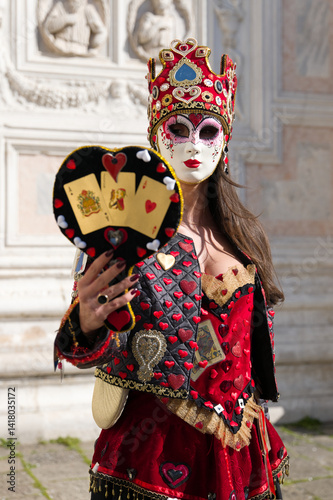 Venice, Italy - People dressed in carnival masks are photographed by tourists in the scenery of the ancient Venetian palaces