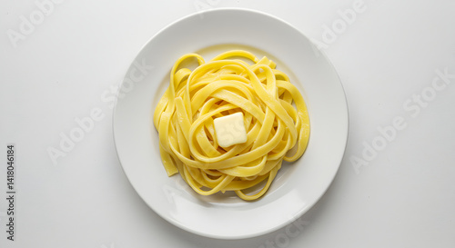 Freshly Made Tagliatelle Pasta Nest Topped with Melting Butter Cube