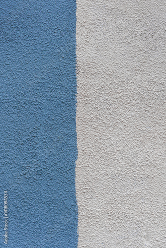 A wall with a blue and white stripe is painted on it. The blue stripe is on the left side of the wall, while the white stripe is on the right side.