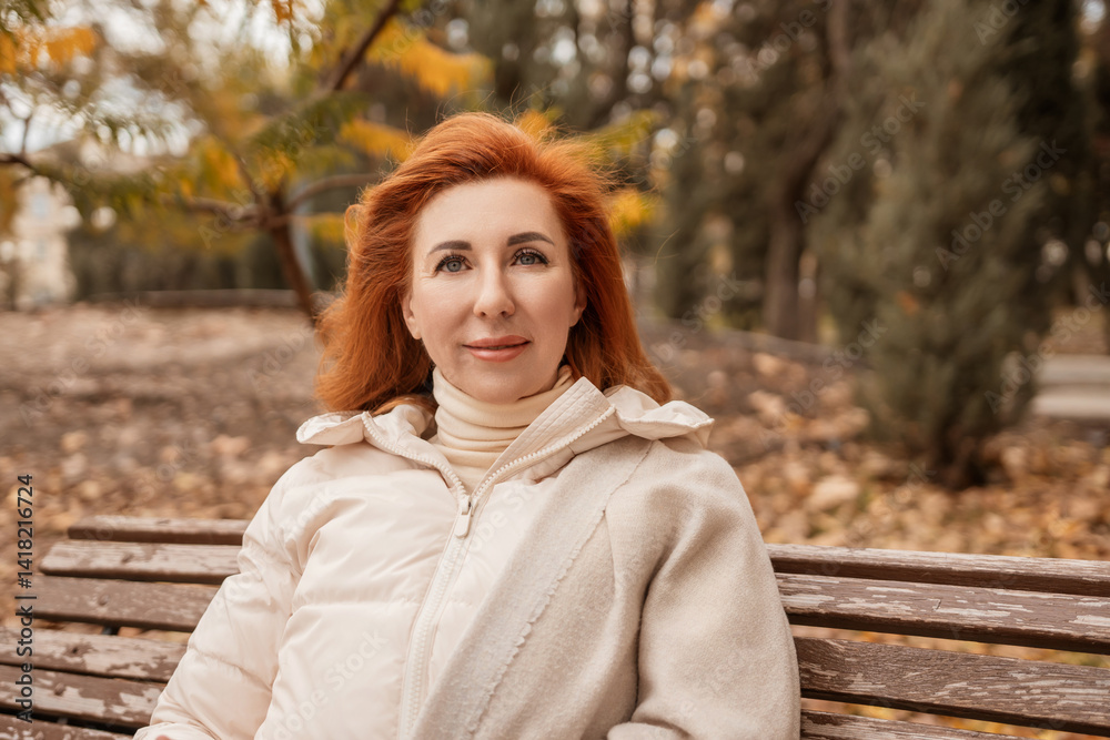 Woman Redhead Autumn Park: Portrait of a redhead woman sitting on a bench in an autumn park. Woman Redhead Autumn Park: Portrait of a redhead woman sitting on a bench in an autumn park.