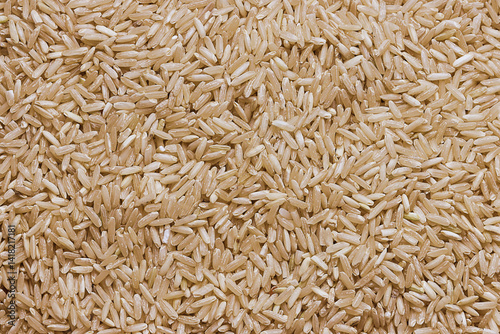 Overhead view of brown rice on white background