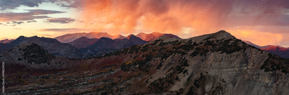 Obraz premium Colorful rain shower above Peeler Peak and the Elk Range mountains outside of Crested Butte Colorado during a dramatic autumn sunset.