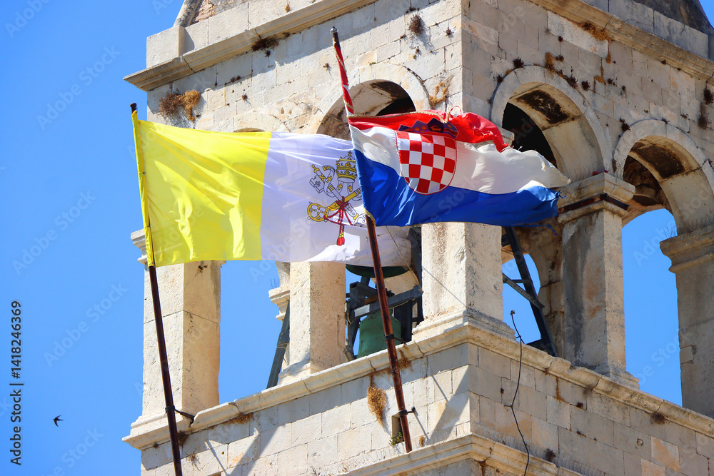 Historical church and monastery of Saint Dominic, in Trogir, Croatia. Flags of Croatia and Vatican City on the tower.