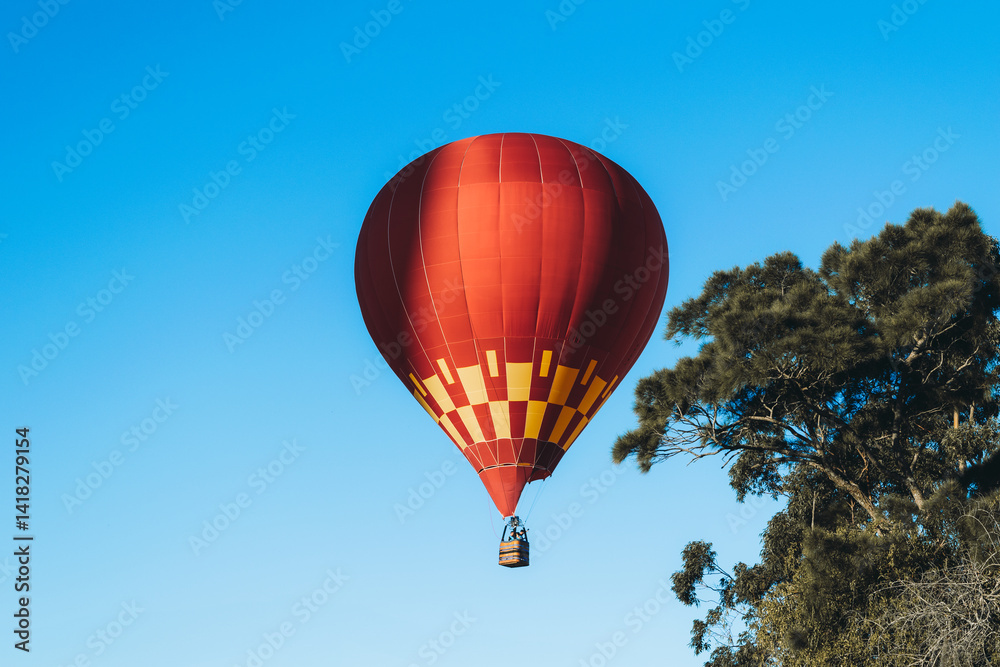 Fototapeta premium Balão de ar quente voando no céu azul. Espaço para escrita.