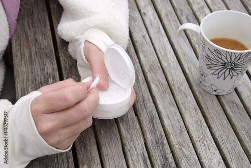 A woman holds one bag of snus in her hand.A box of snus pads replaces smokeless cigarettes. Swedish nicotine pouch.