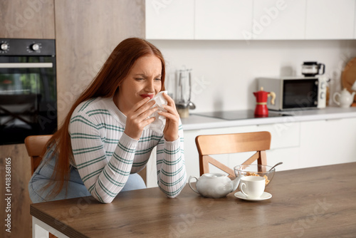 Allergic young woman sneezi...