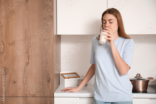 Young woman drinking milk i...