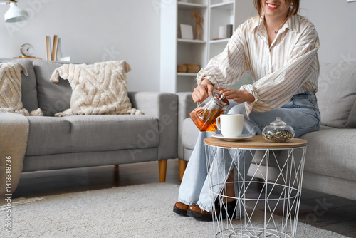 Young woman pouring hot tea...